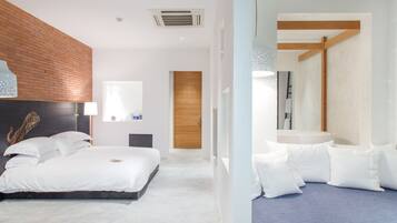 A modern bedroom with a large bed, a wooden headboard, a bedside table, and a nightstand.