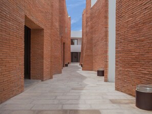 A narrow brick corridor with a clear sky above. - Sala Ayutthaya (Ayutthaya)