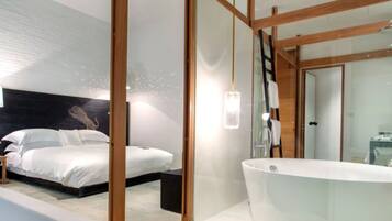A modern bedroom with a large bed, a built-in bathtub, and a wooden ceiling structure.