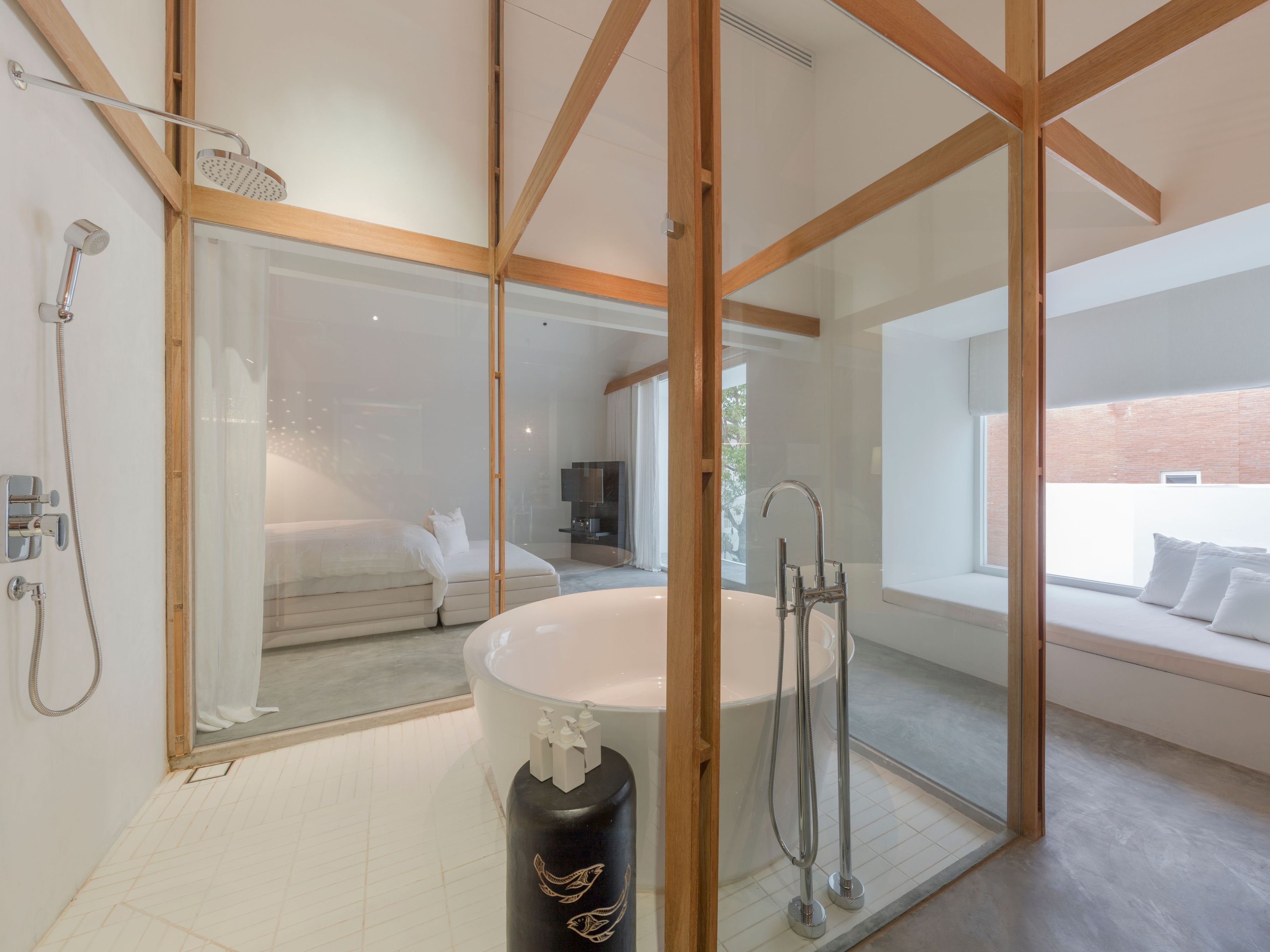 Un baño moderno con una bañera independiente, zona de ducha y cabina de ducha con mampara de vidrio.