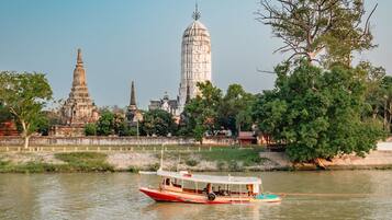 A boat on a river with temple structures in the background.