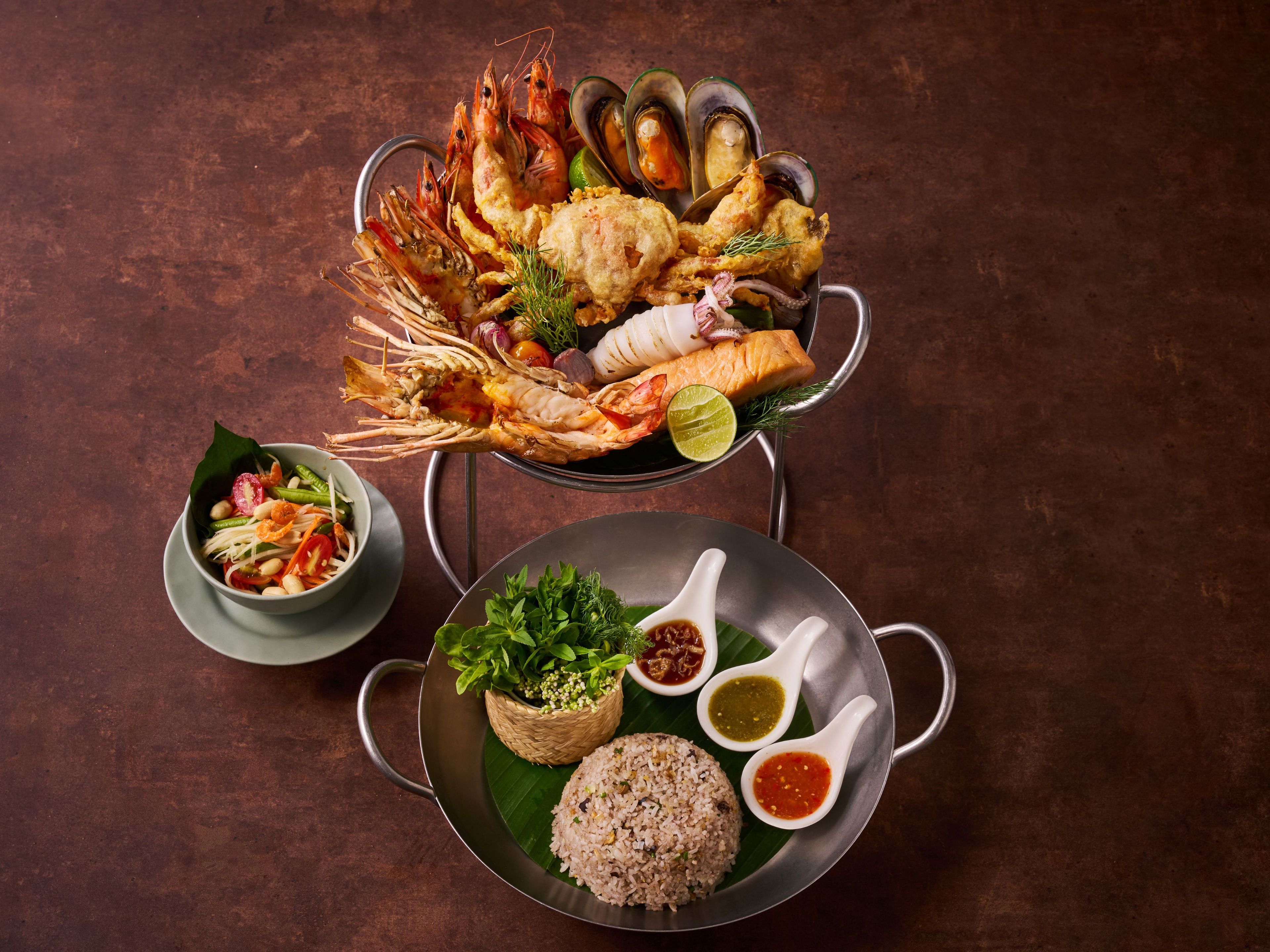 A variety of seafood dishes including shrimp, mussels, and salmon, served with rice and condiments.