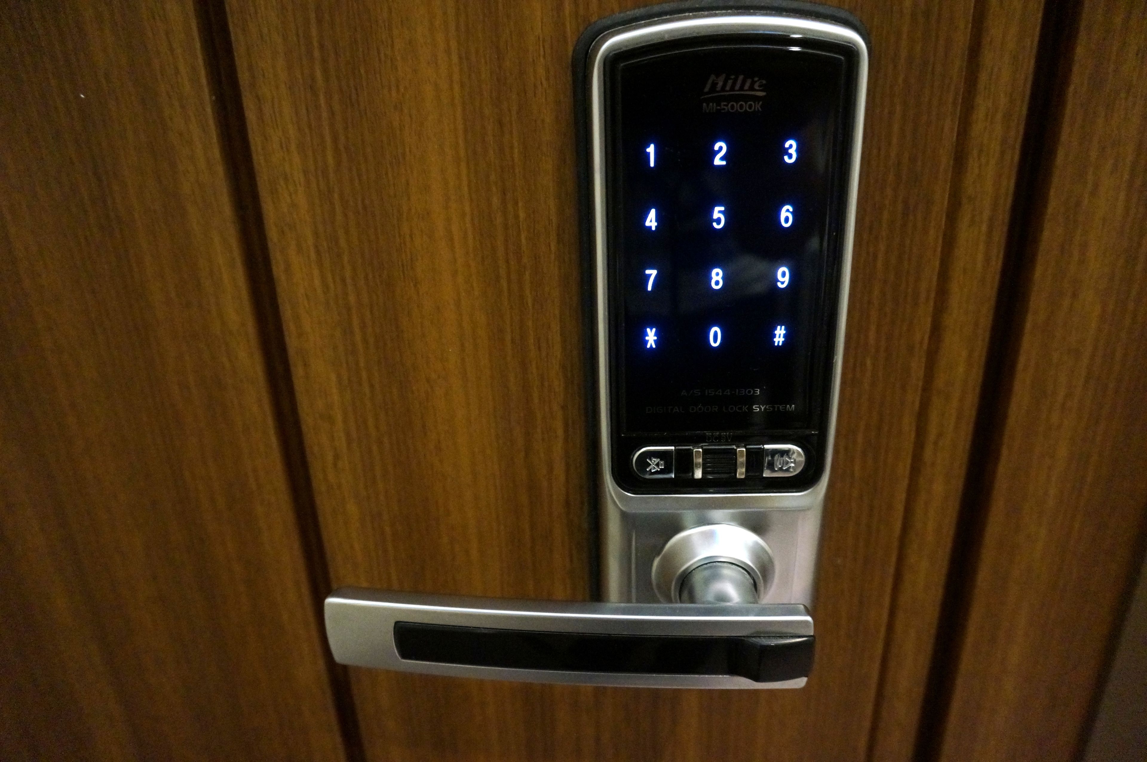 Un système de verrouillage de porte numérique doté d’un clavier numérique et d’un bouton-poussoir.