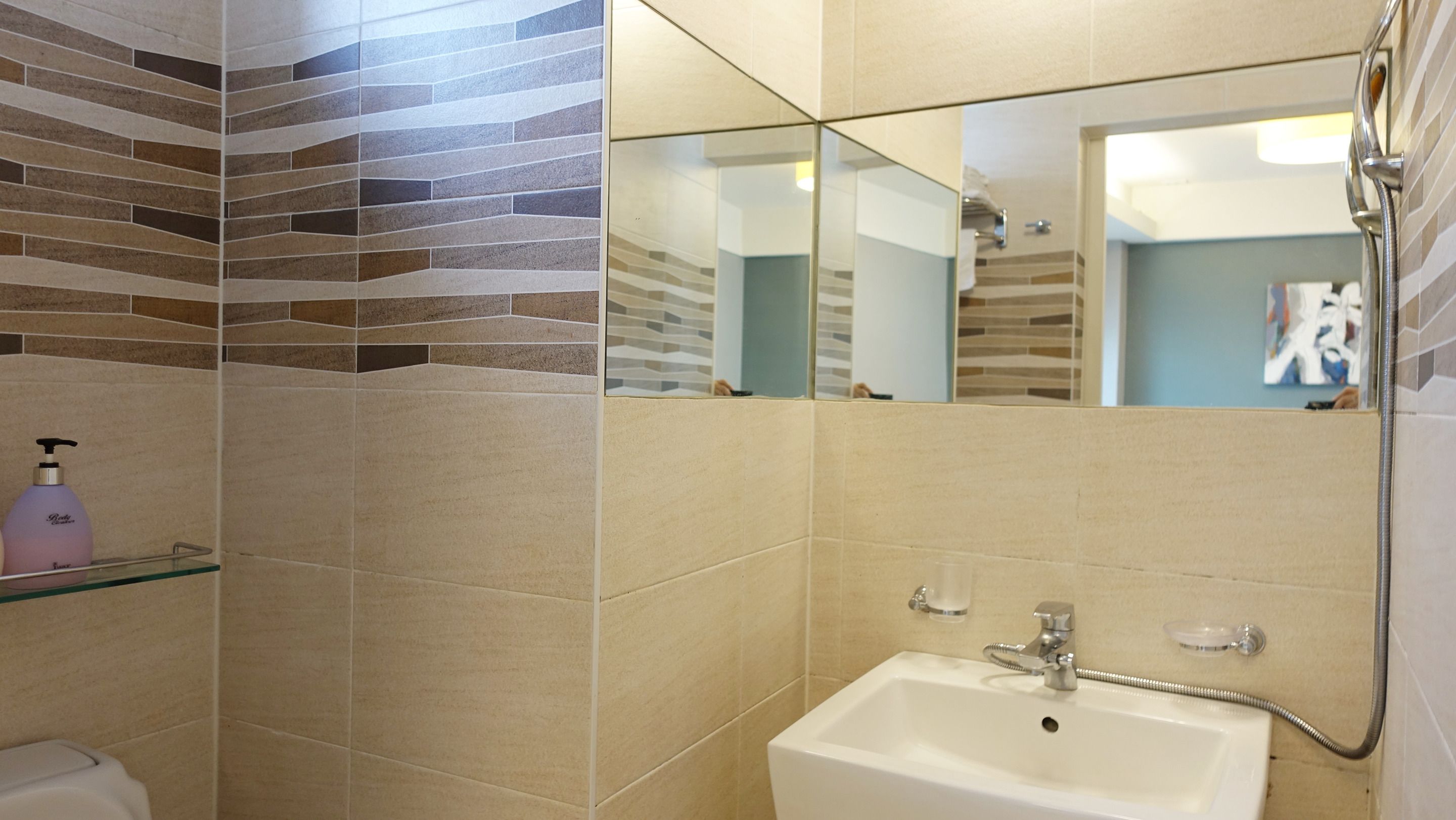 A bathroom with a white sink, a mirror, and a shower.