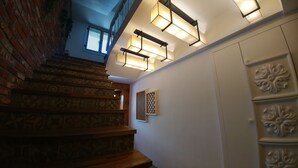 Un escalier orné de carreaux décoratifs et de marches en bois mène à un palier agrémenté de panneaux muraux décoratifs et doté d’une fenêtre offrant une vue.