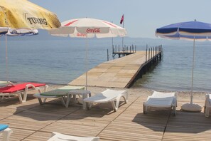 En privat strand, liggestole, parasoller