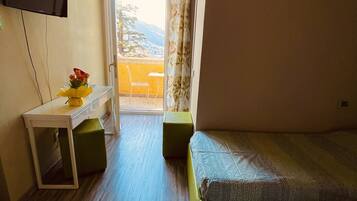 Ein Hotelzimmer mit Bett, Schreibtisch, Stuhl und Blick ins Freie.