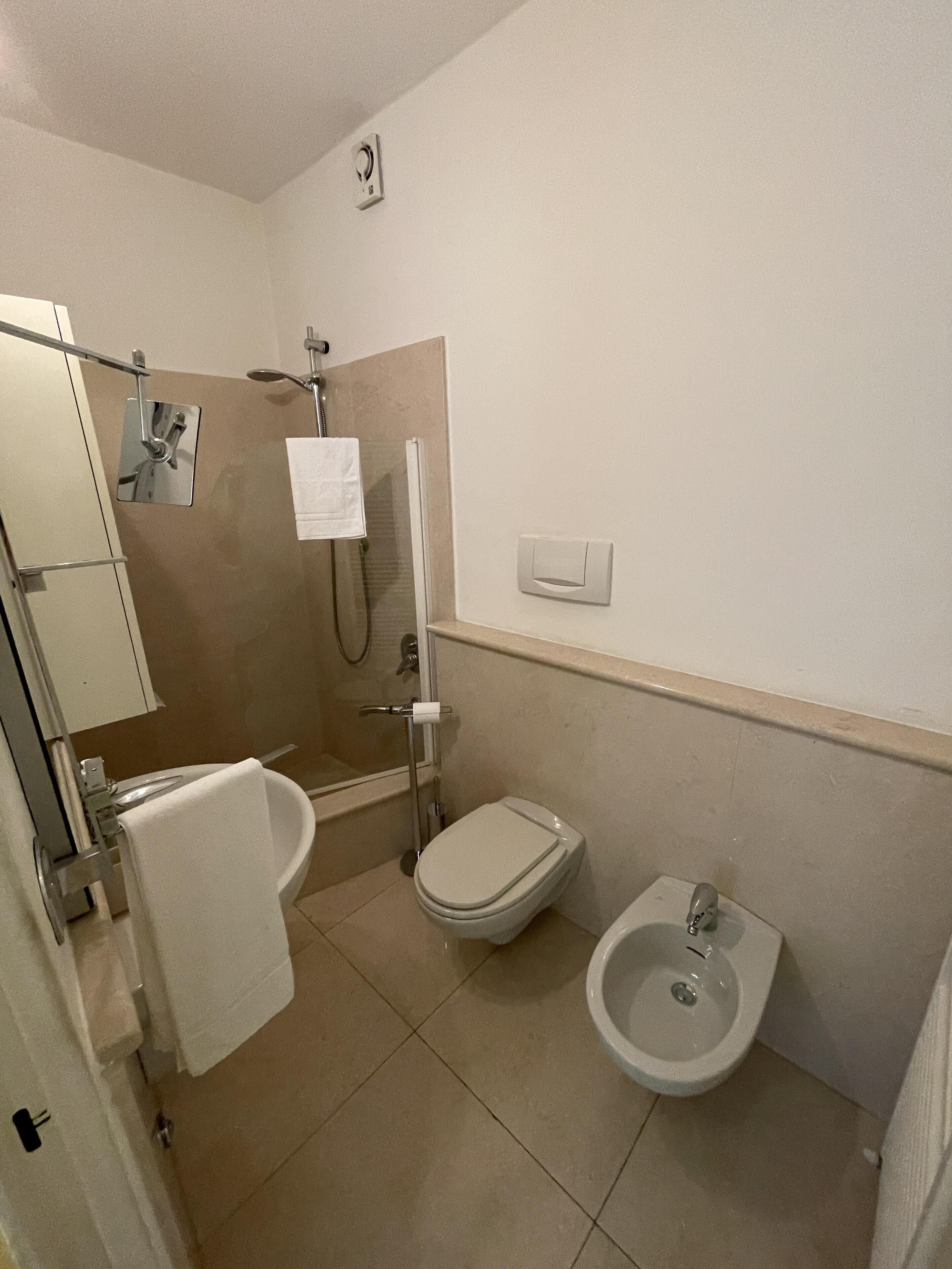 Un bagno con WC, bidet e zona doccia.