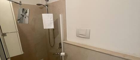 Een badkamer met toilet, bidet en een douchehoek.