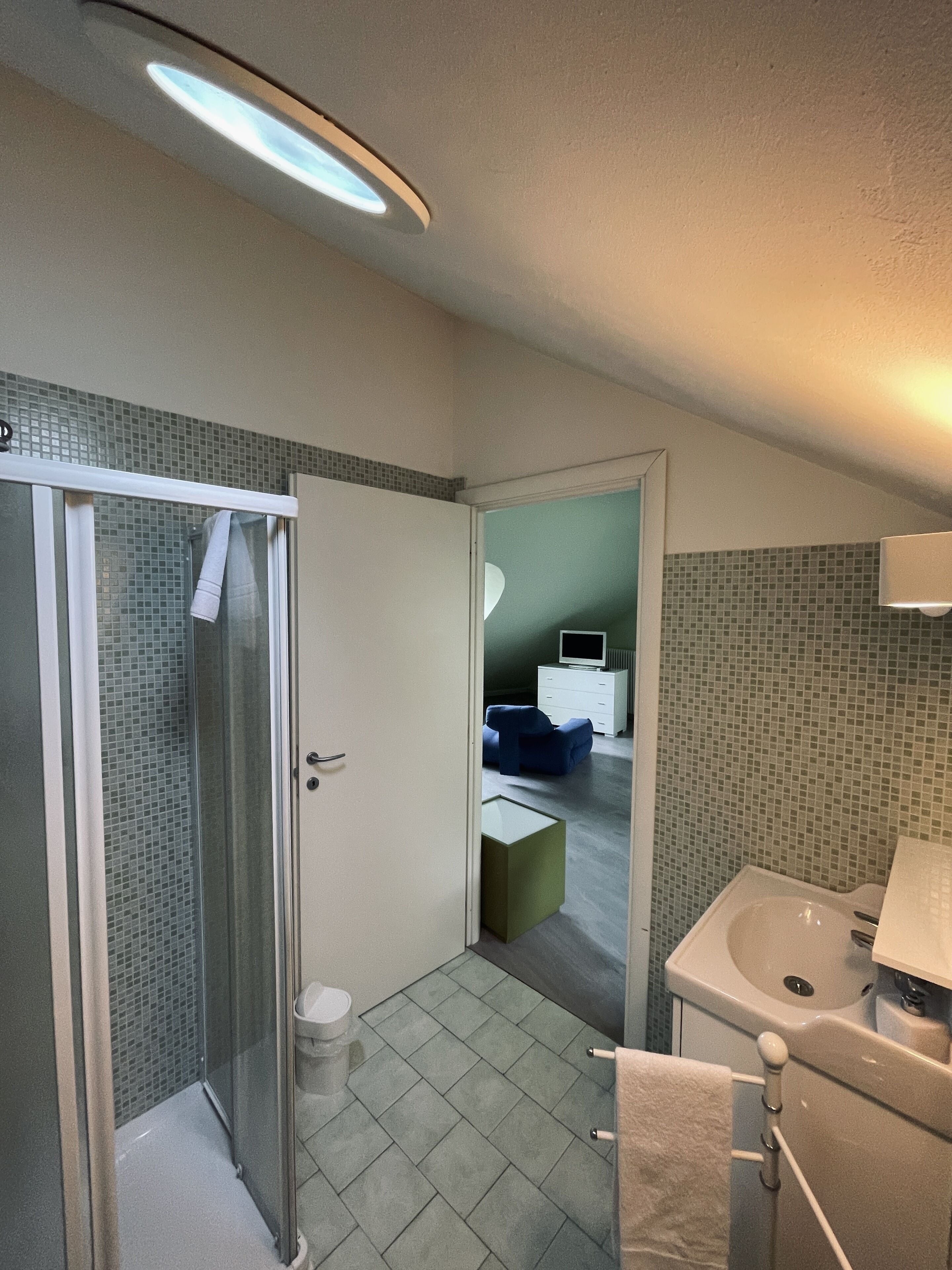 Ein Badezimmer mit Dusche, Toilette, Waschbecken und Spiegel.