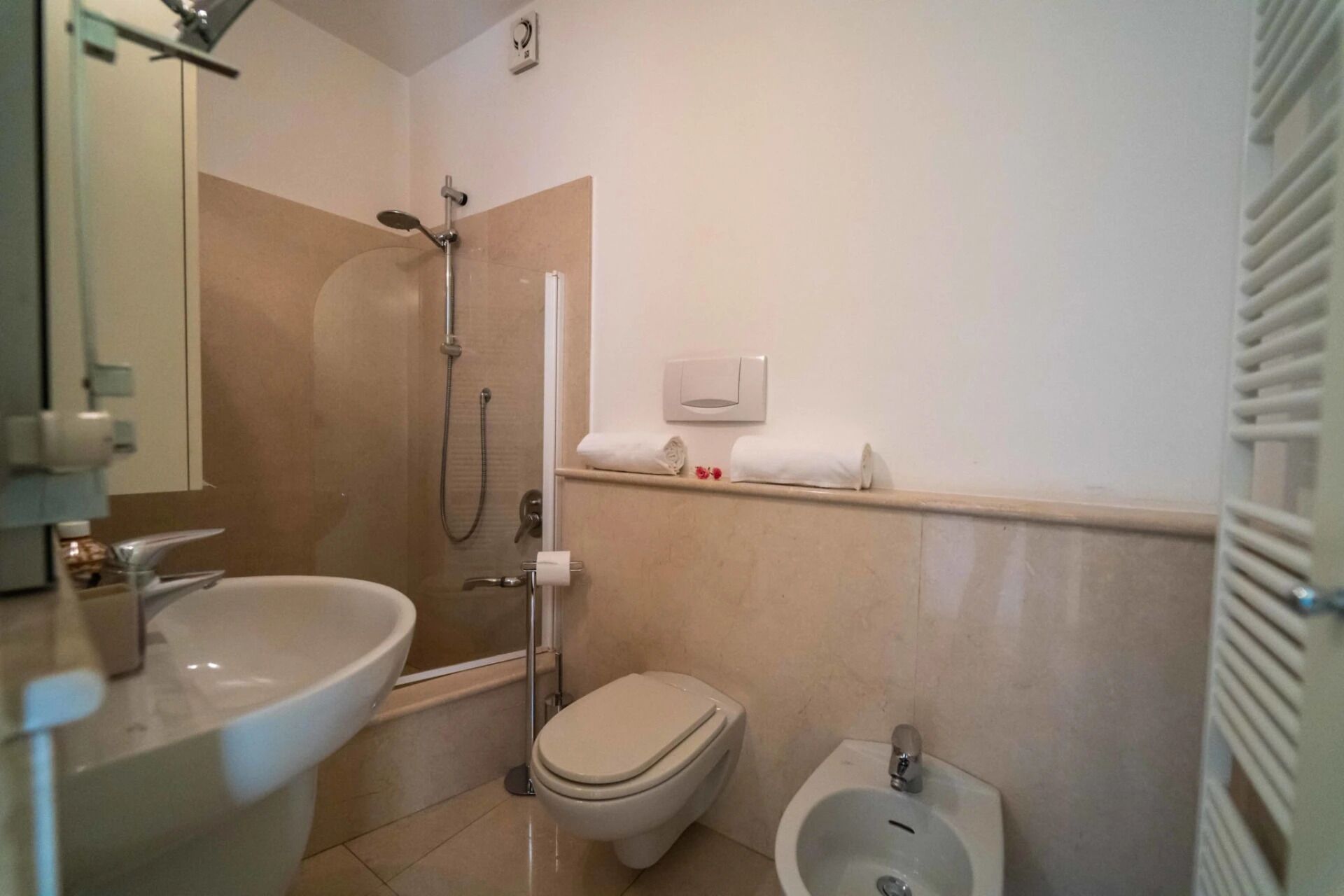Un baño con ducha, inodoro, bidé y lavamanos.