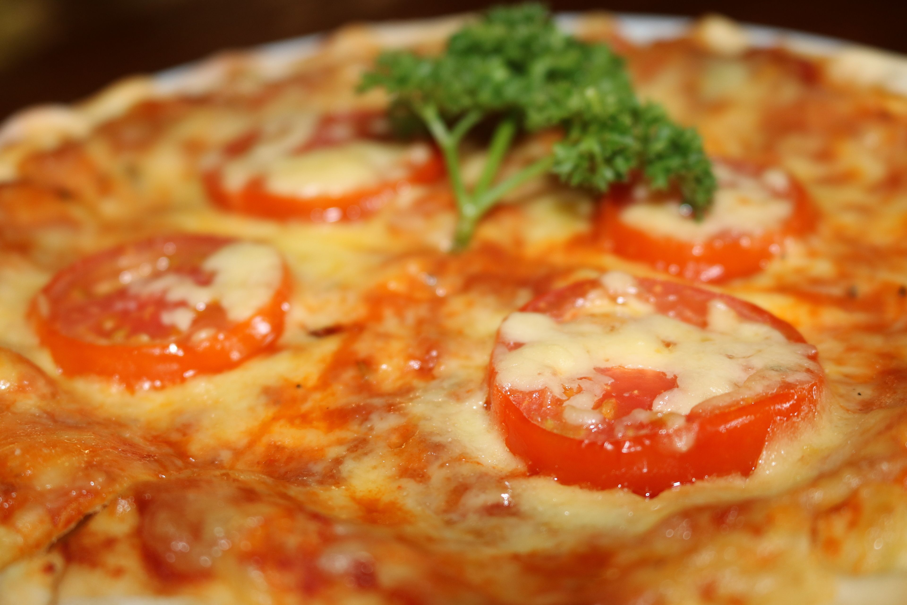 Una pizza con rodajas de tomate y queso.