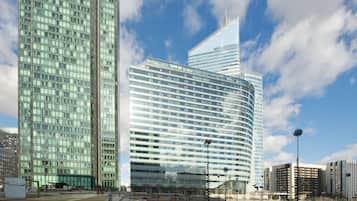 A modern high-rise building with a curved facade and reflective glass windows.