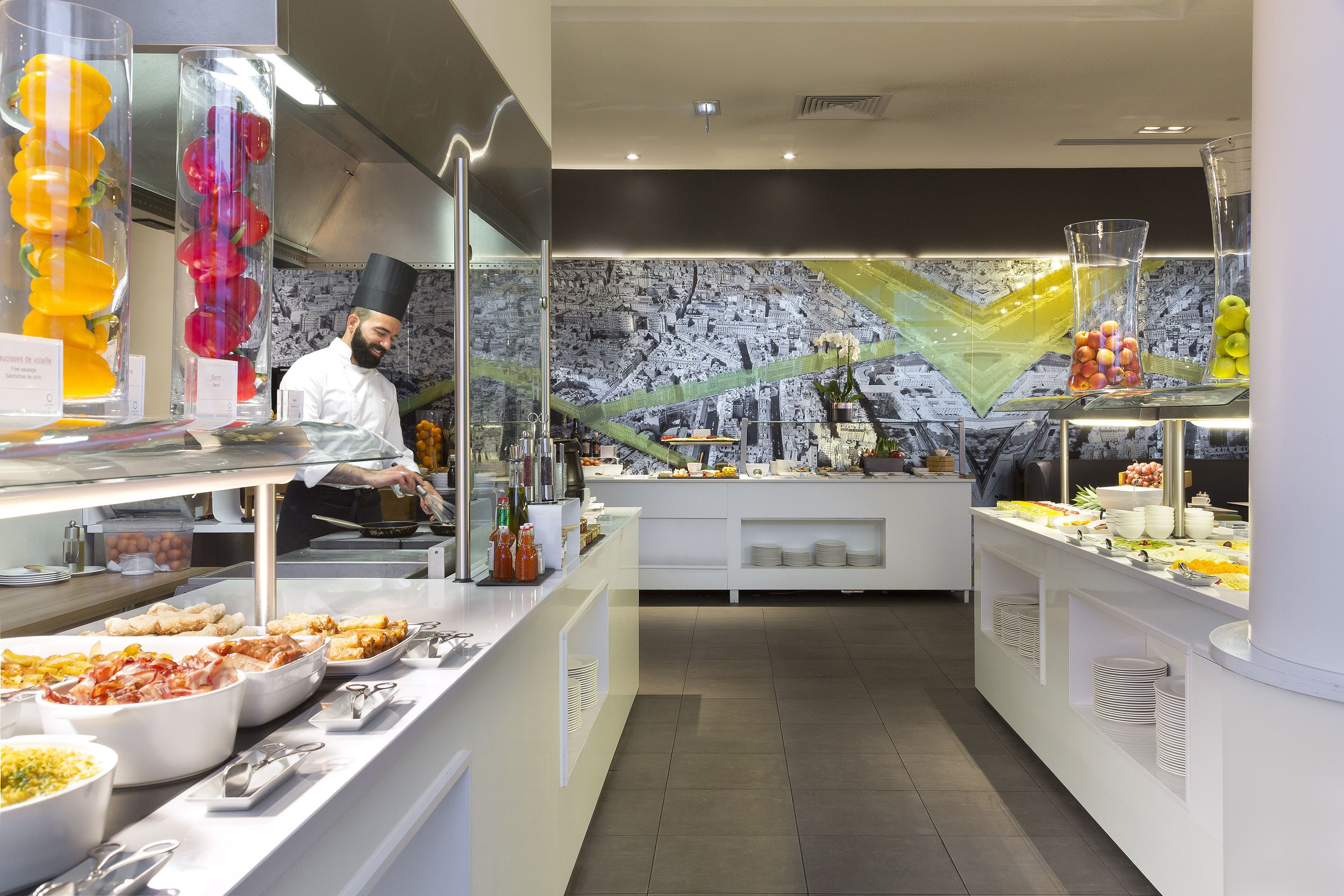 A buffet area with various food items and a chef preparing food.