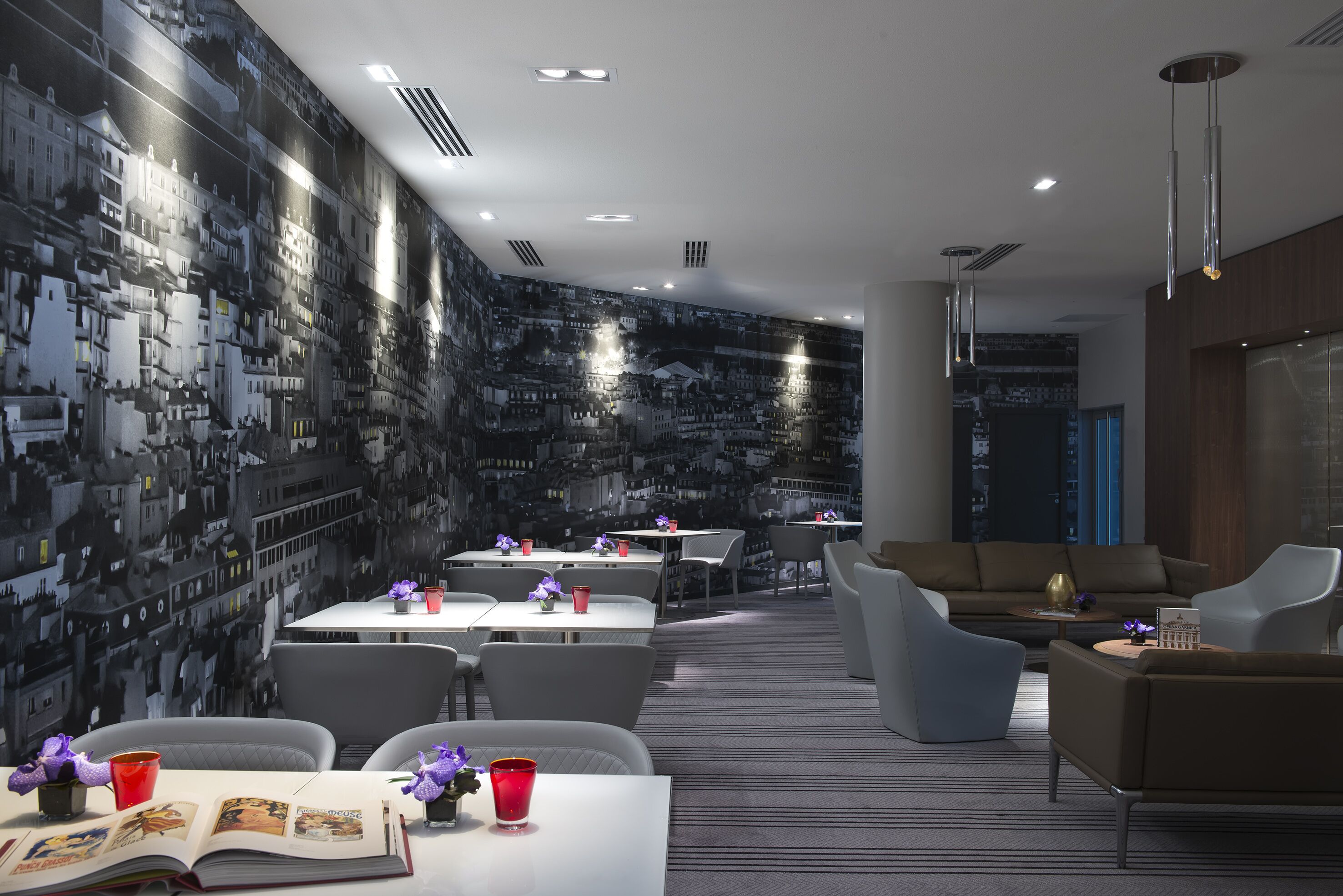 A modern interior with a cityscape mural, dining area, and seating.