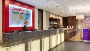 Un área de recepción moderna con un mapa digital, mostrador de recepción y zona de bar/lounge.