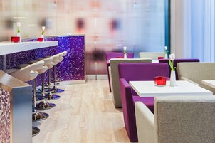 Ein modernes Restaurant mit Barbereich und violetten Sitzbänken.