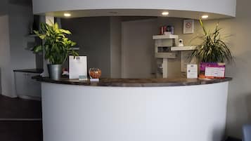 A reception desk with a potted plant, a fishbowl, and informational brochures.