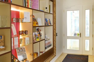 A reception area with a glass display case containing brochures and a welcome mat.