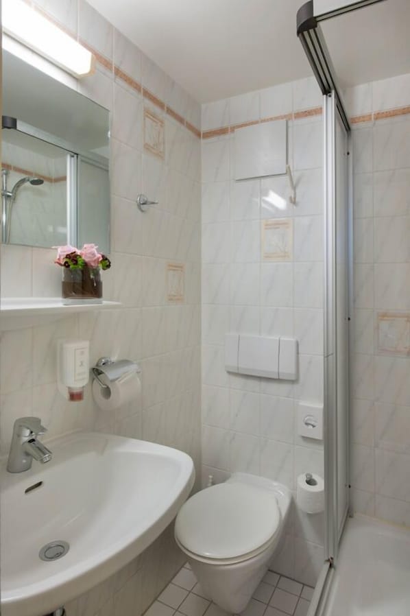 A bathroom with a sink, toilet, and shower.