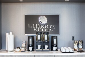 A coffee station with multiple coffee makers, cups, and coffee bags labeled "Liberty Suites." - Liberty Suites Hotel (Markham)