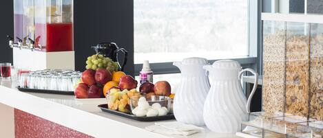 Un bufé de desayuno con frutas, huevos y cereales.
