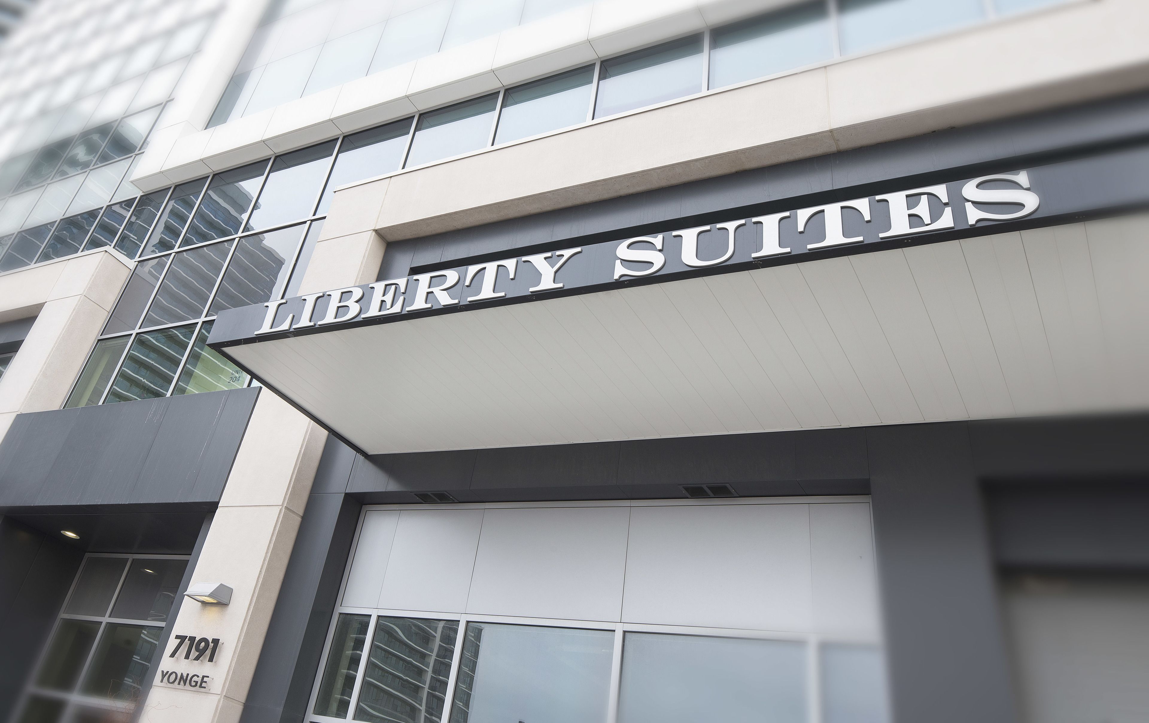 Un edificio con un letrero que dice "LIBERTY SUITES" y un número de teléfono visible "7191 YONGE".