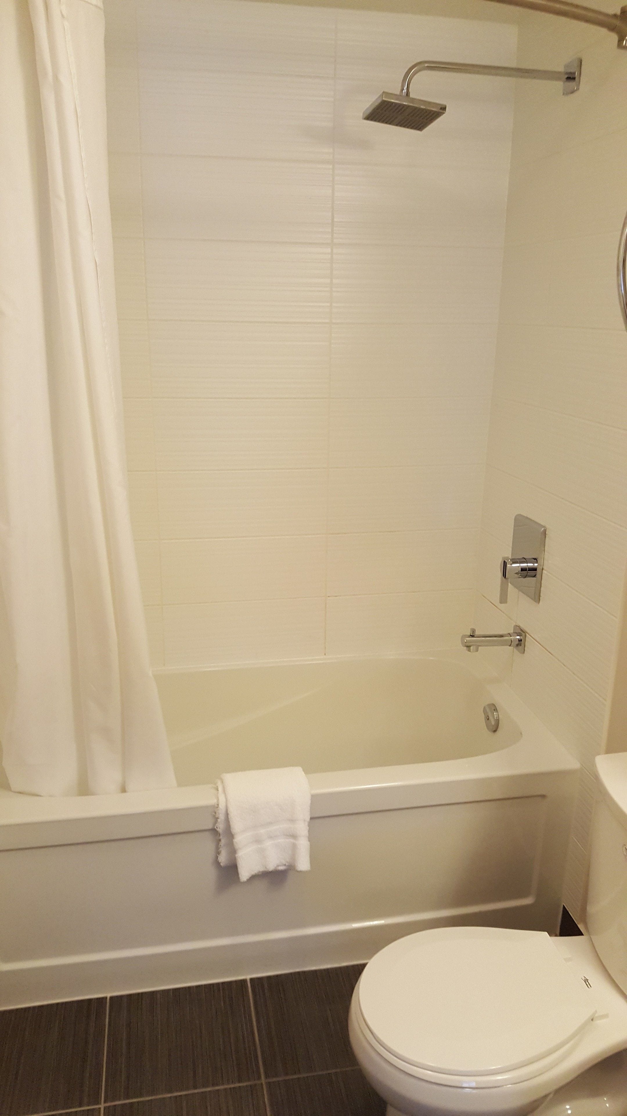 A bathroom with a bathtub, toilet, and shower.