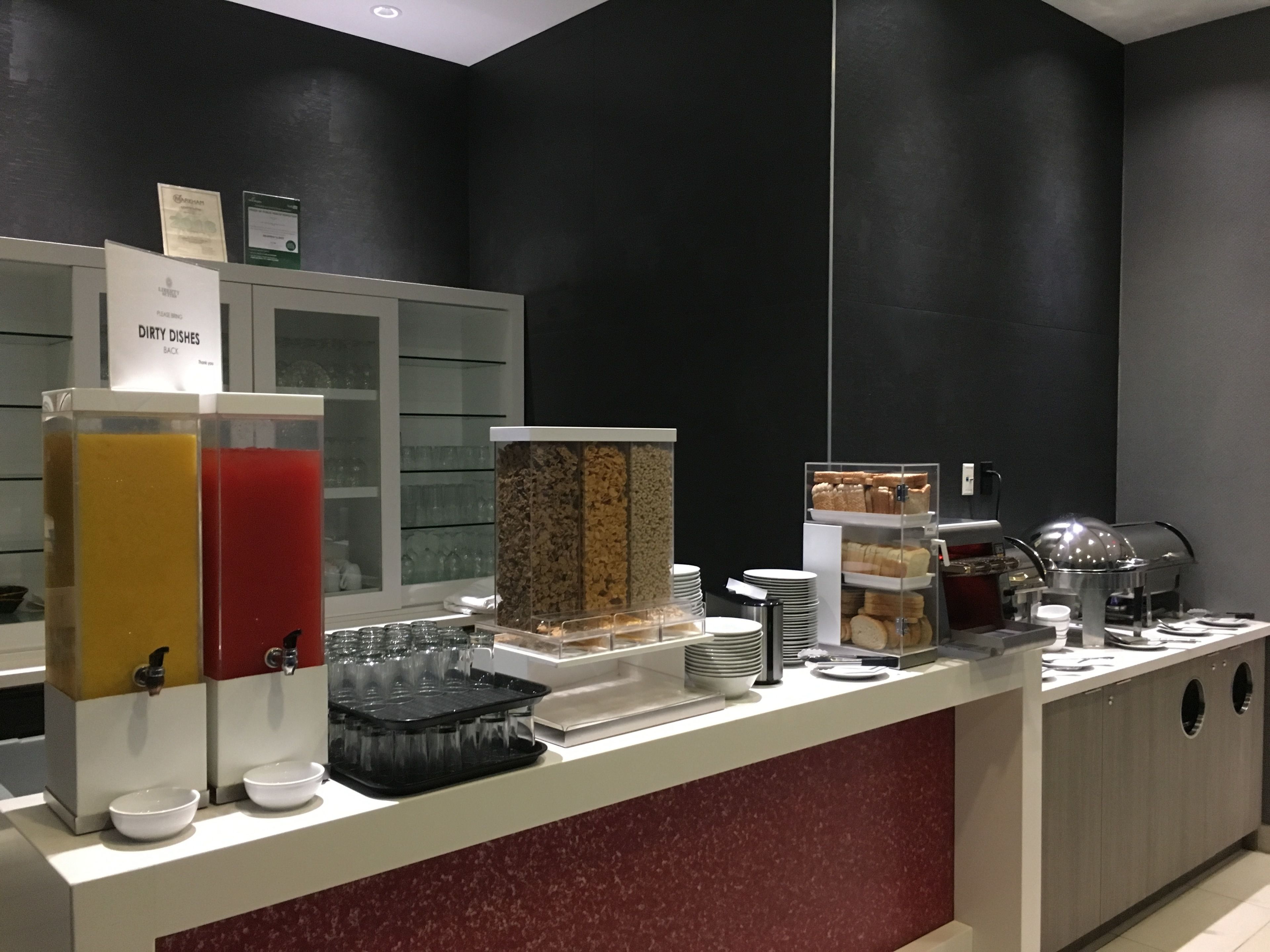 A buffet area with various food items, a coffee machine, and a sign indicating a 'Dirty Dishes' area.