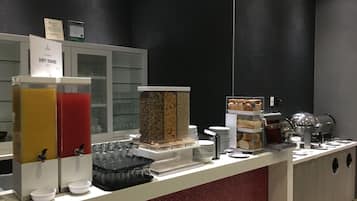 A buffet area with various food items, a coffee machine, and a sign indicating a 'Dirty Dishes' area.