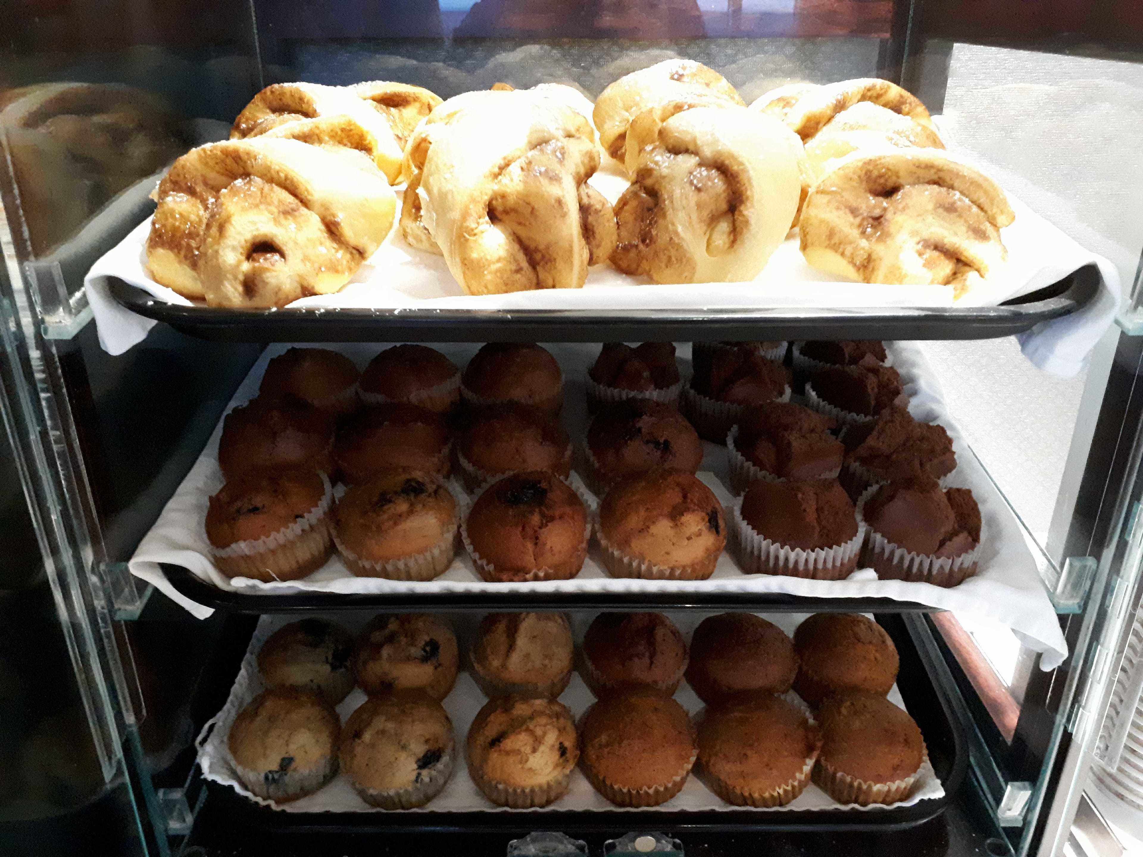 Un expositor de pastelería con pasteles y muffins.