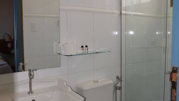 A bathroom with a sink, toilet, and glass-enclosed shower.