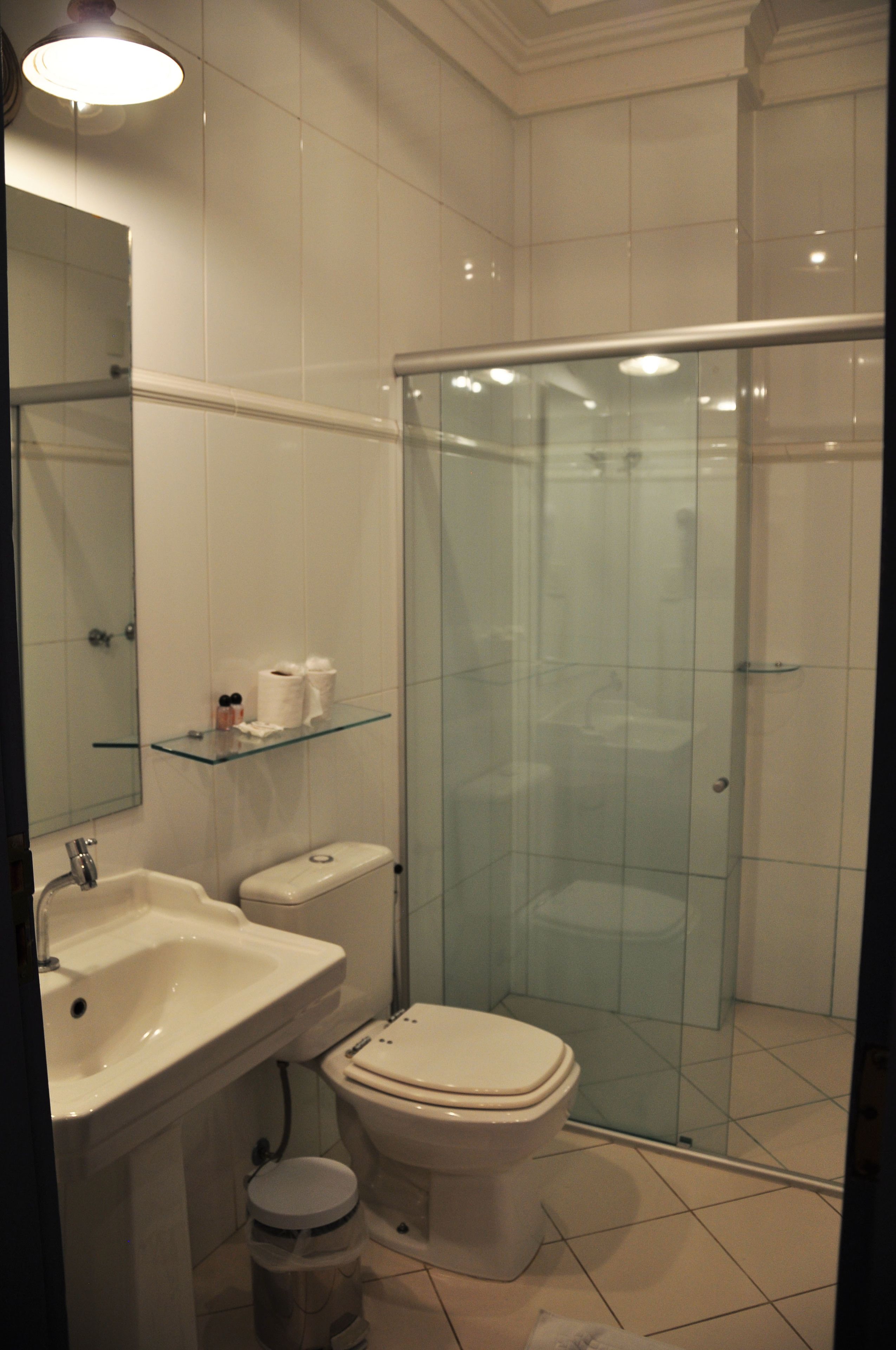 A bathroom with a glass shower enclosure, a sink, and a toilet.