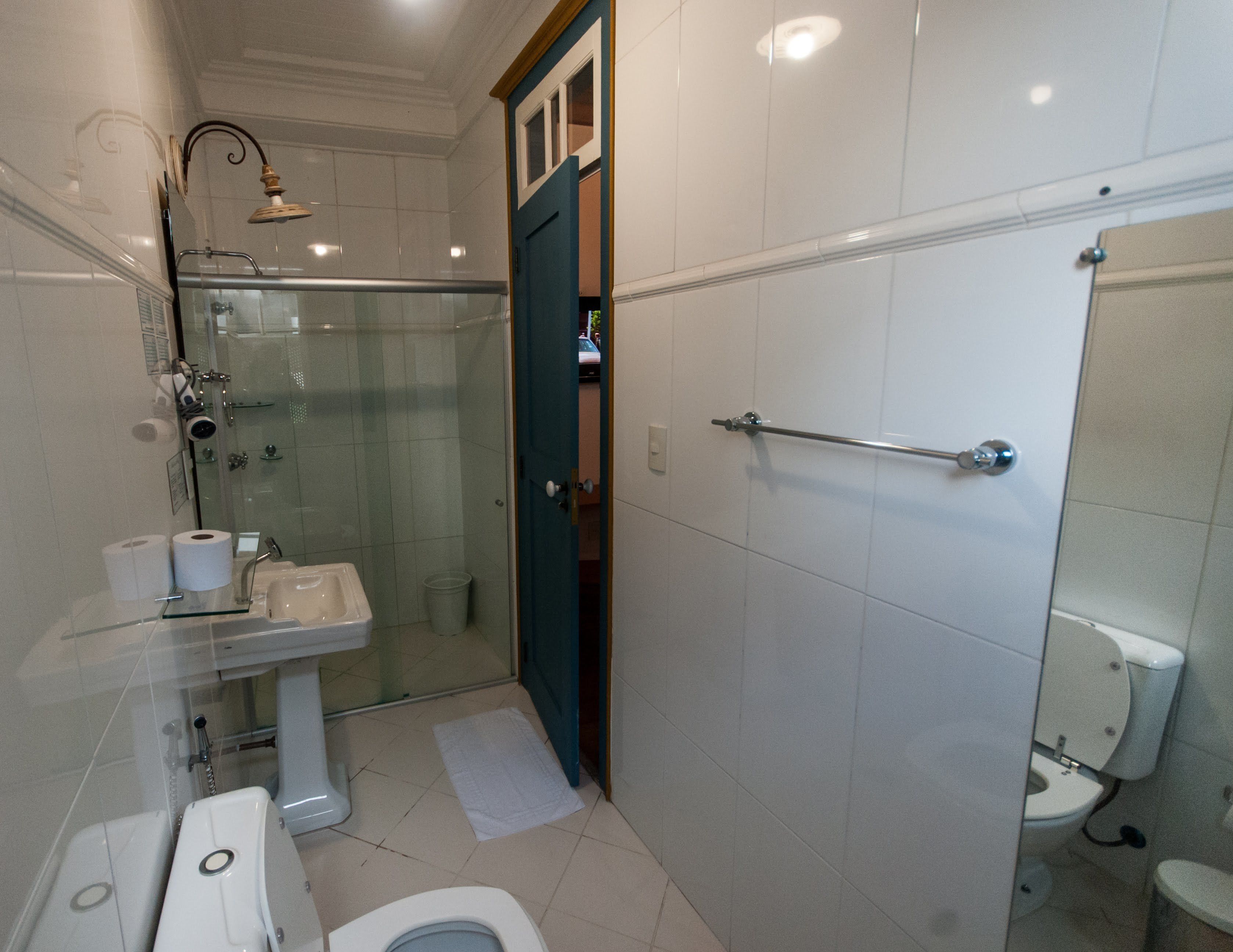 Une salle de bain moderne avec une douche à parois de verre, un lavabo sur colonne, des toilettes et un bidet.