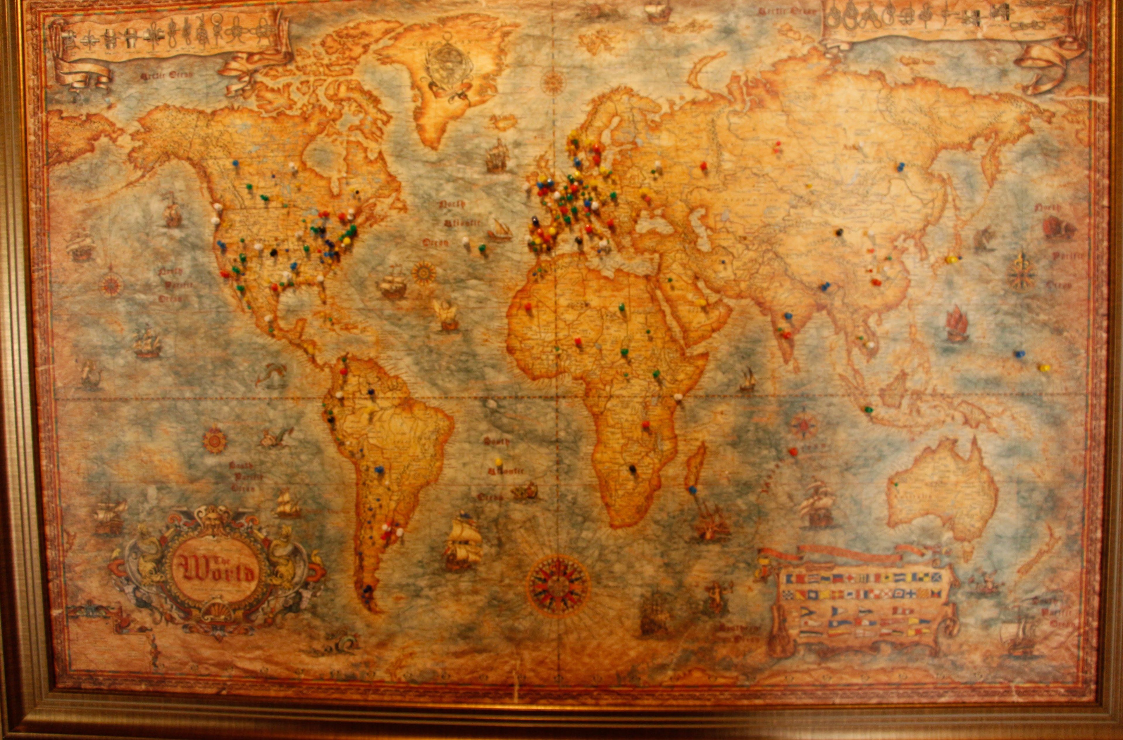 A vintage world map with various pins and symbols, likely indicating locations of interest or historical events.