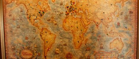 A vintage world map with various pins and symbols, likely indicating locations of interest or historical events.