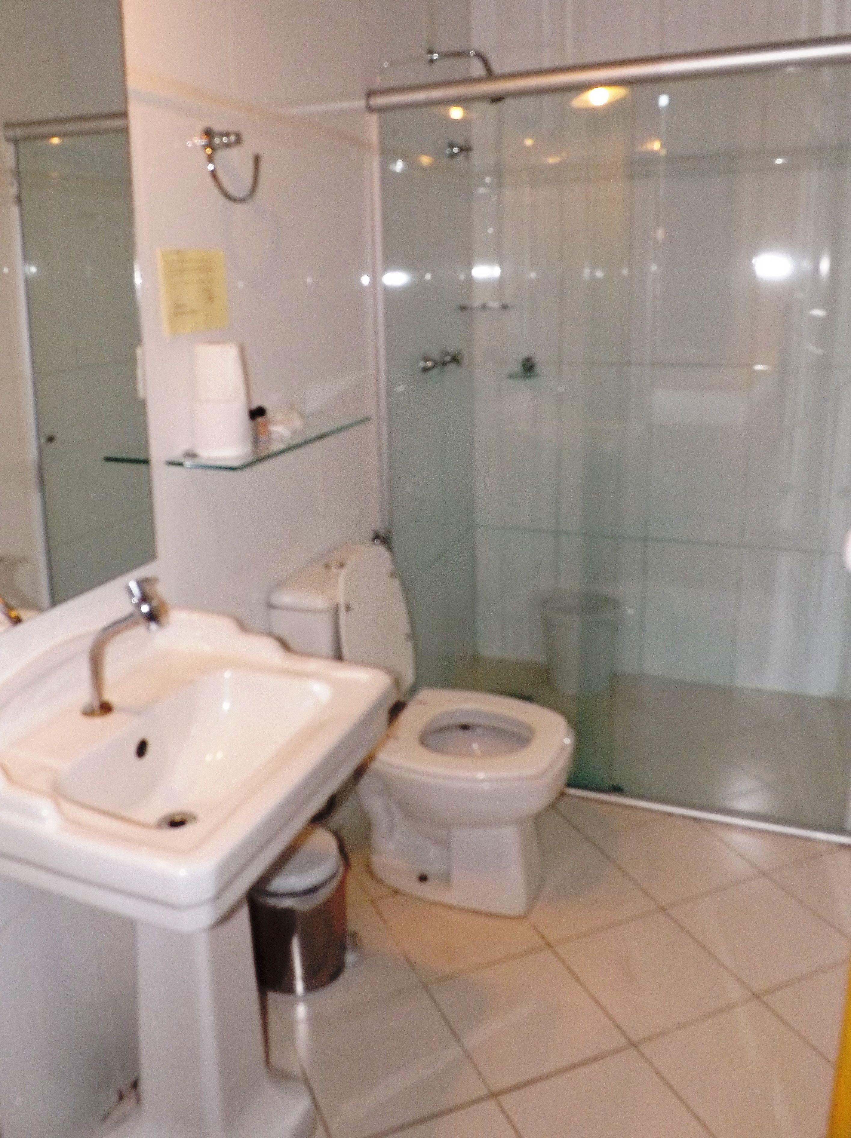 A bathroom with a sink, toilet, and glass-enclosed shower.