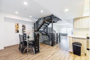 A modern kitchen with a wooden countertop and a black trash bin. - Heaven on Hollywood Boulevard Furnished Apartments (Los Angeles)
