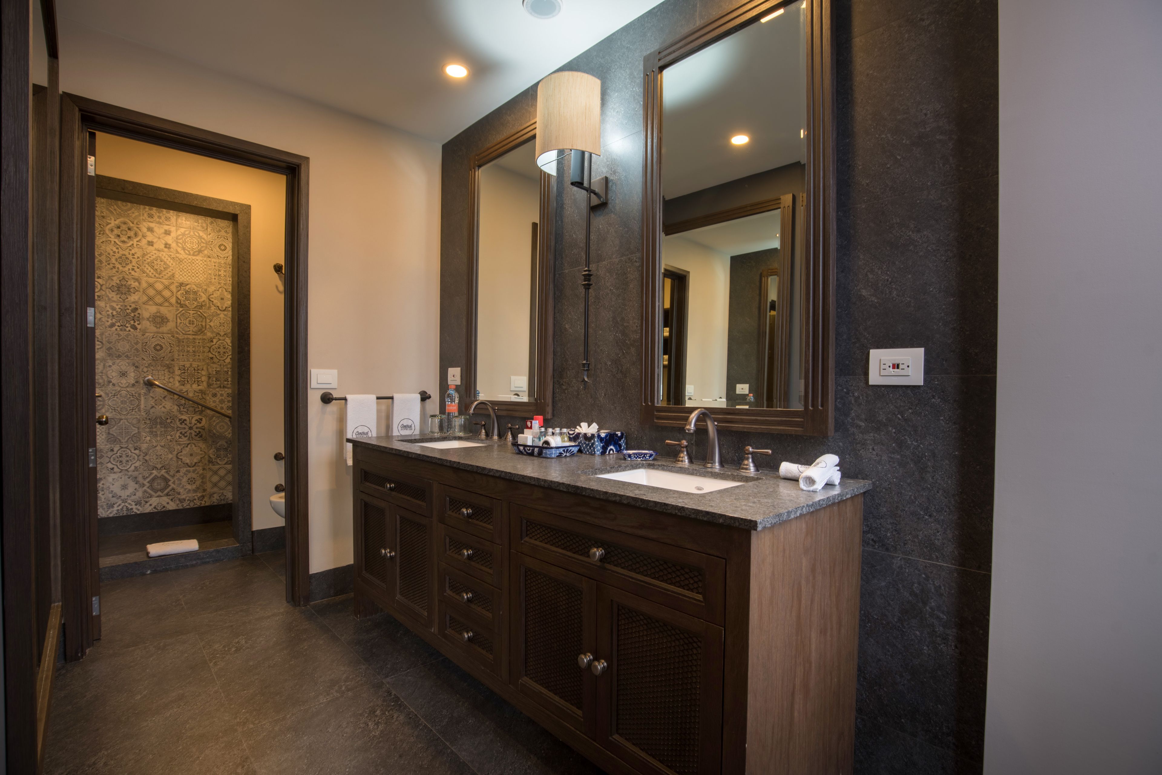A modern bathroom with a double sink vanity, dark wood cabinetry, and a large mirror.