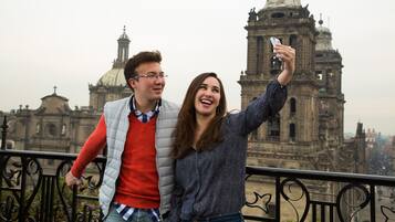 Una pareja se saca un selfie con un edificio histórico de fondo.