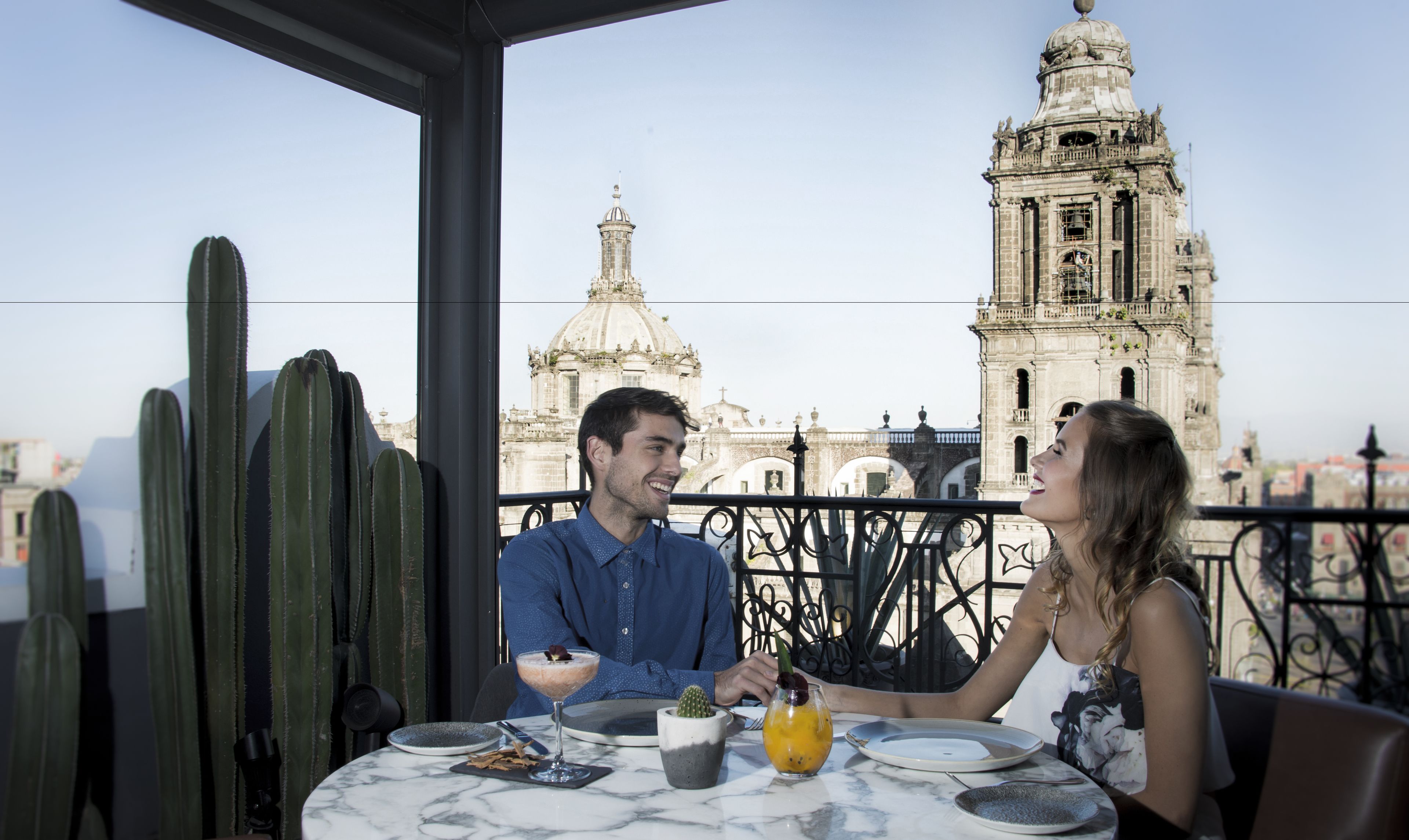 A couple dining at a table with a view of a historic building in the background.