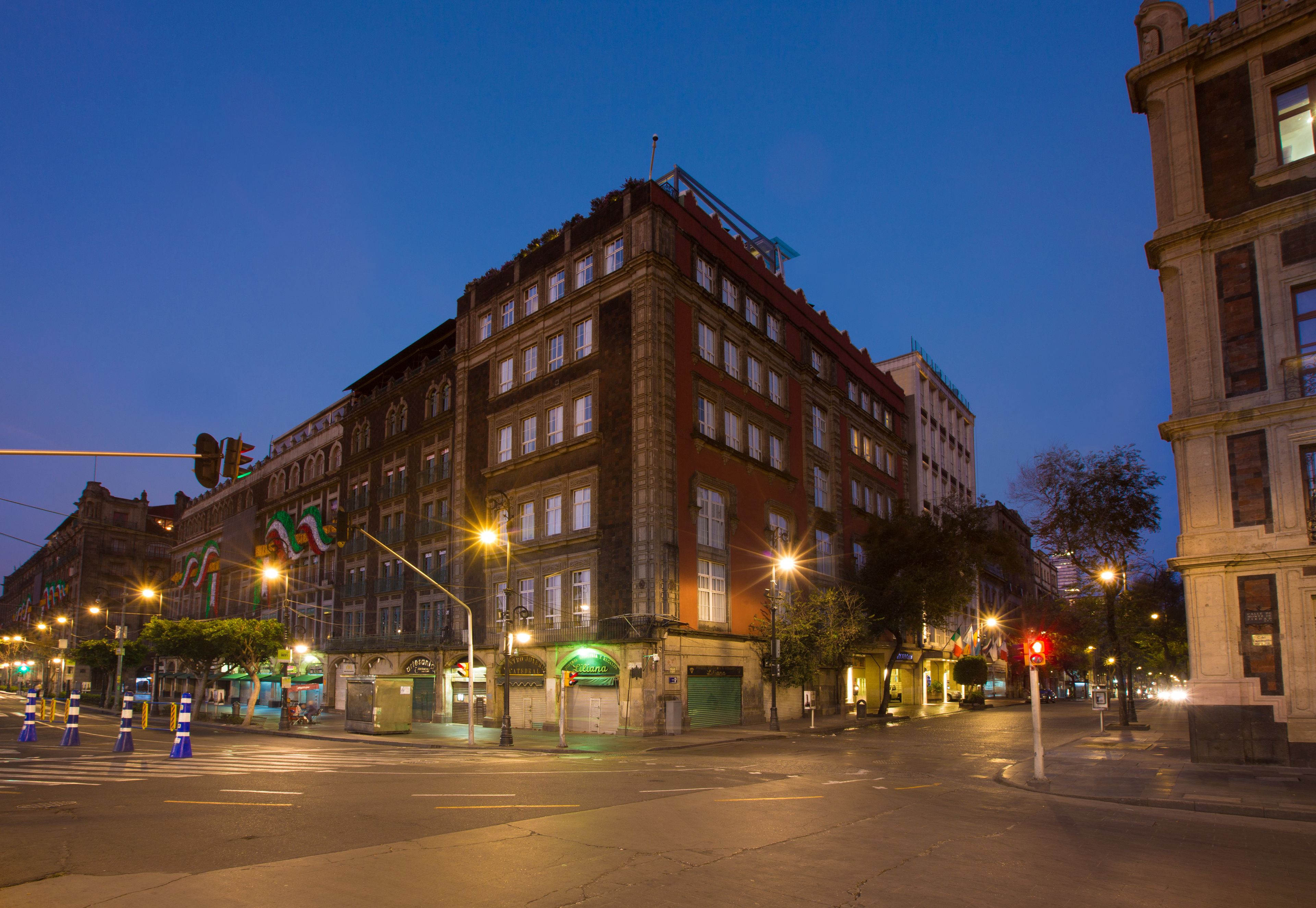 Un edificio histórico con varios pisos, ventanas amplias y una entrada destacada en la esquina.
