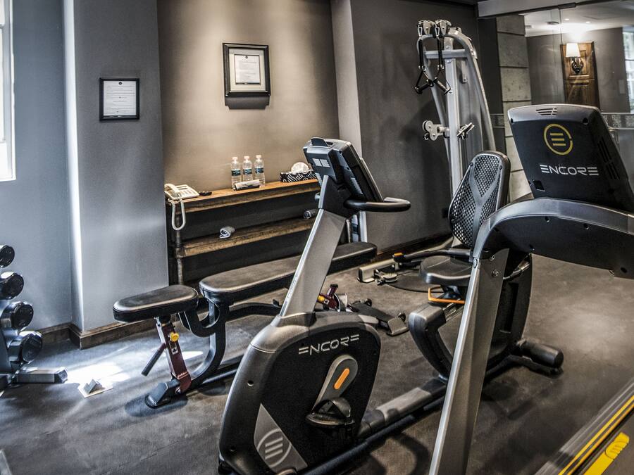 A gym with exercise equipment, a reception desk, and a water bottle on the counter.