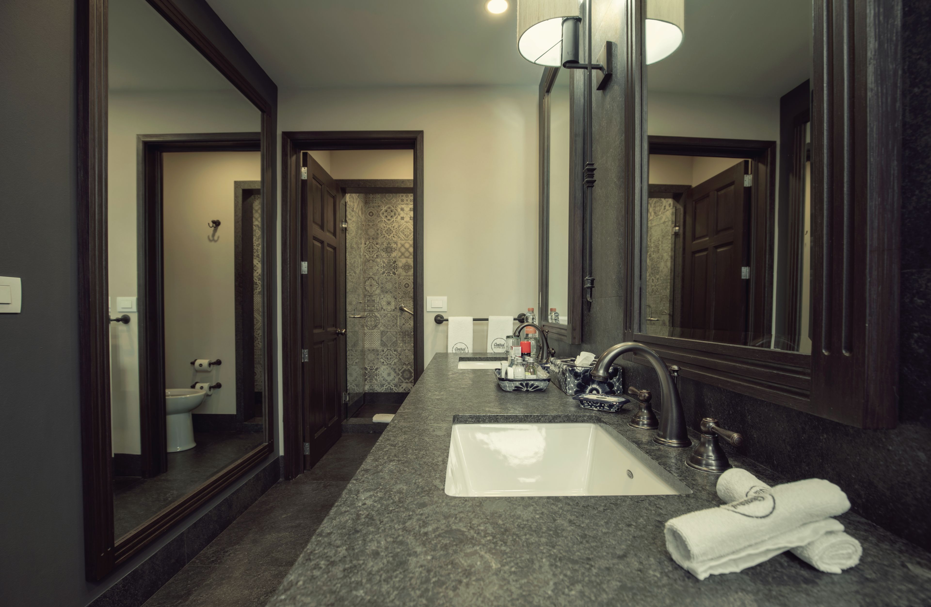 Un baño con un espejo grande, un lavabo y un inodoro.