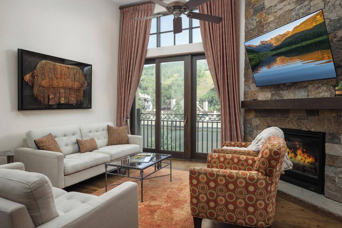 A living room with a sofa, armchair, and fireplace.