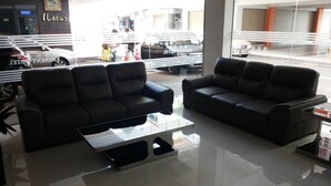 A modern interior with two black leather sofas and a glass coffee table. - Eminent Hotel (Kota Kinabalu)