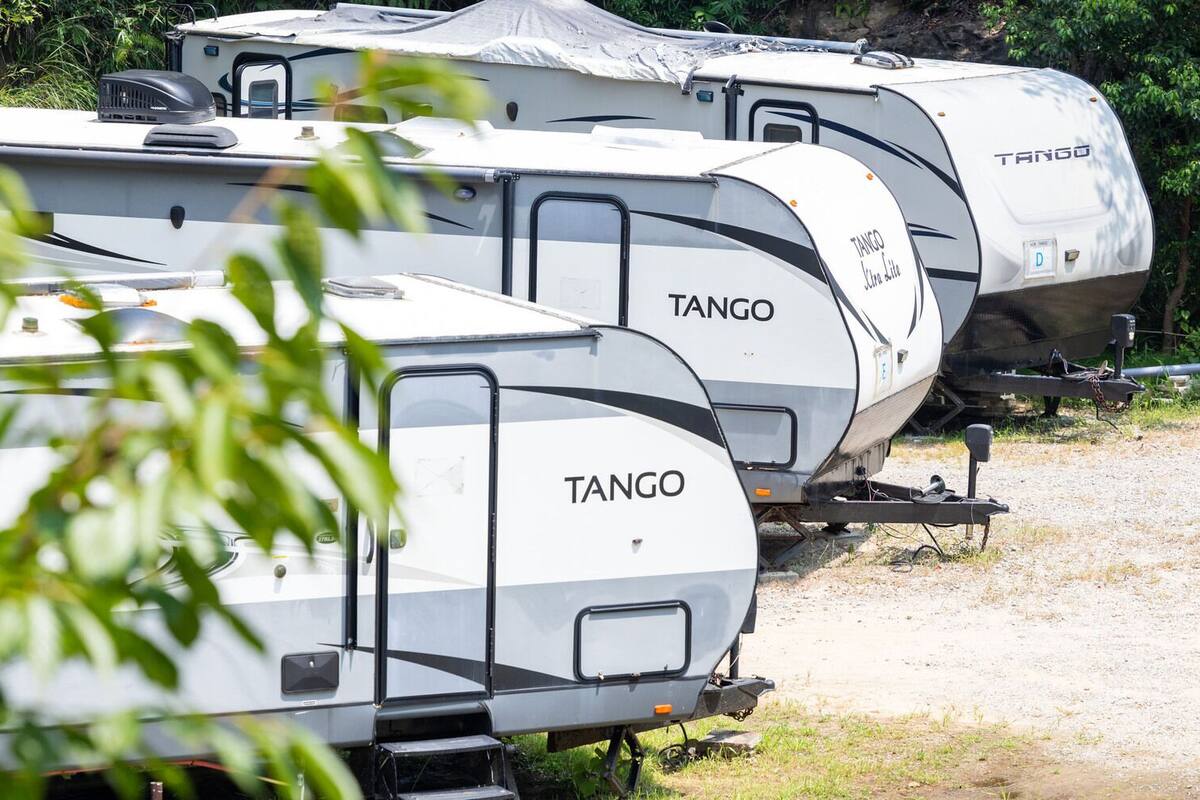 Várias caravelas TANGO estacionadas ao ar livre, com portas e janelas visíveis.