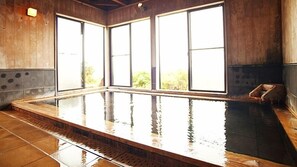 Relax in a spacious room with a large hot tub and ample natural light through the multi-paned windows.
