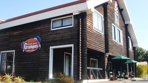 Welcome to Woody House Grampus, a charming two-story retreat with a cozy entrance and inviting windows.