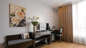 Ein modernes Wohnzimmer mit einer Holzbank, einem Fernseher, einer Vase mit Blumen und einem großen Fenster mit Vorhängen.